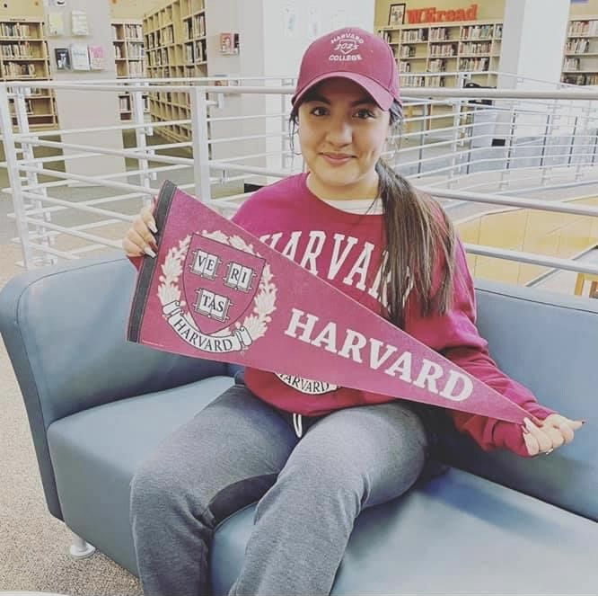 Reyna Lopez Garcia holding a Harvard pennant